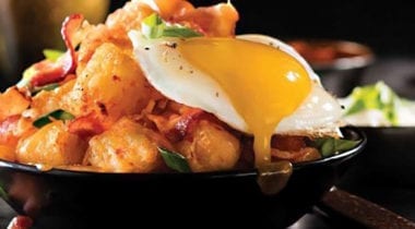 tater tots topped with bacon and eggs