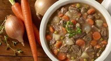 beef stew in a bowl with carrots and onion