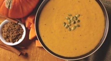 pumpkin bisque soup topped with toasted pumpkin seeds