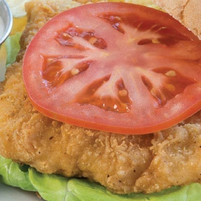 fried chicken on a bun with lettuce and tomato