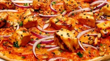 thai chicken with red onions on pizza