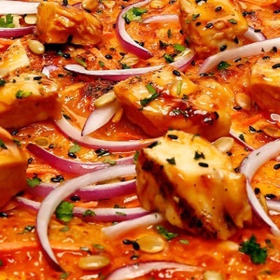 thai chicken with red onions on pizza