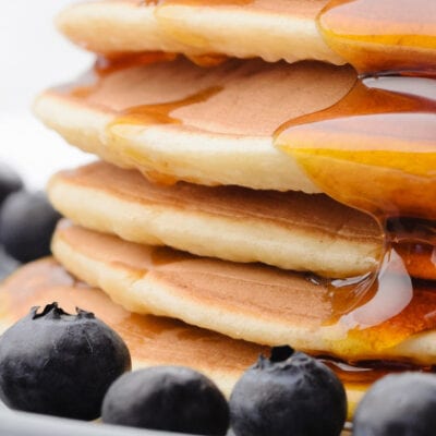 pancakes and syrup surrounded by blueberries