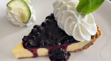 lemon lime pie slice with blueberry sauce and whip cream