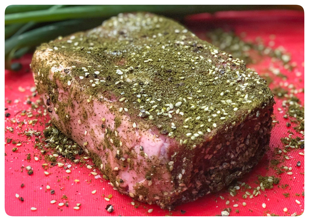 zaatar rubbed cut of beef on red board